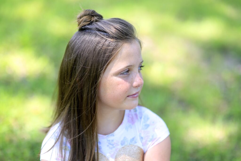 Little girl standing outside modeling Half Up Bun