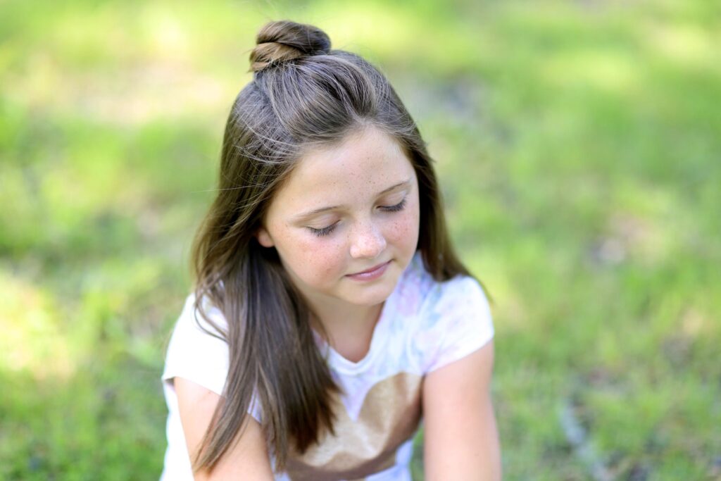 Little girl standing outside modeling Half Up Bun