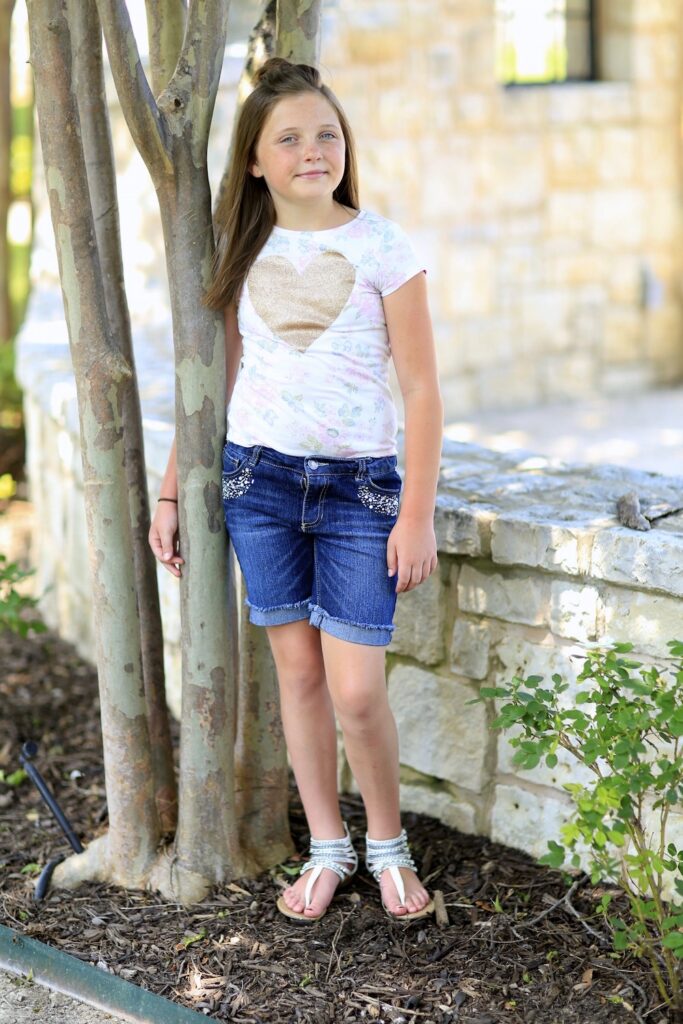 Little girl standing outside modeling Half Up Bun