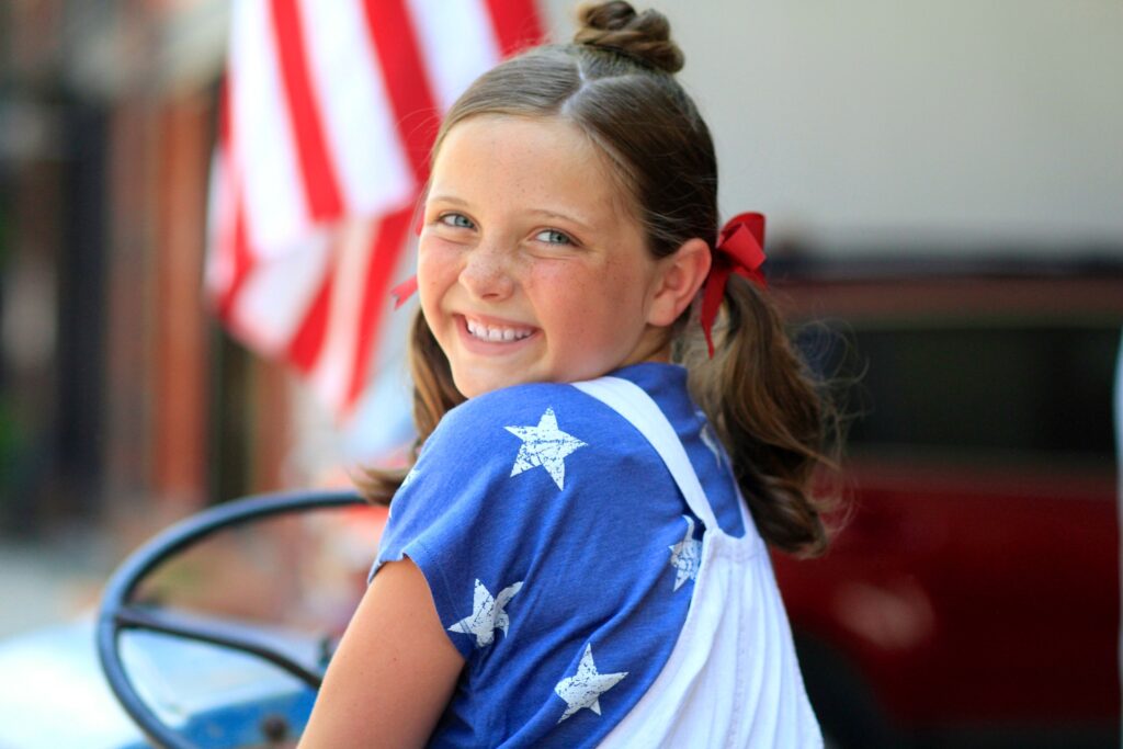 Little girl outside modeling Star Bun Combo | 4th of July Hairstyles