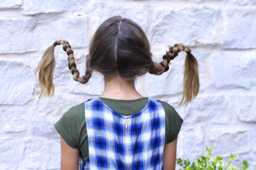 Young girl outside modeling Pippi Longstock Braids | Easy Halloween Hairstyles (Back)