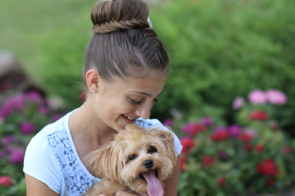 Young girl outside holding a puppy and modeling Lace Fishtail Bun