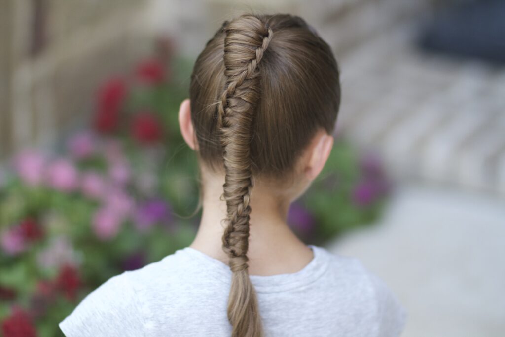 Young girl outside modeling Chinese Staircase Braid (back) 