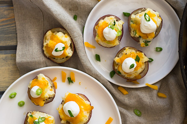 Twice Baked Potato Bites topped with sour cream and chives on a white plate