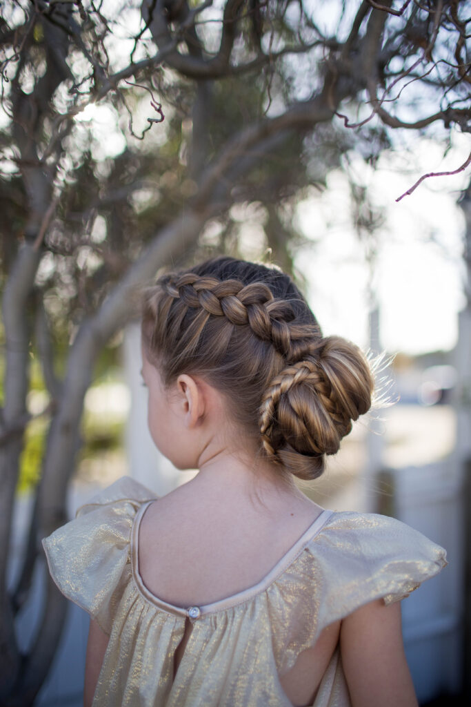 Side view of a little girl outside modeling "Braided Bun" hairstyle
