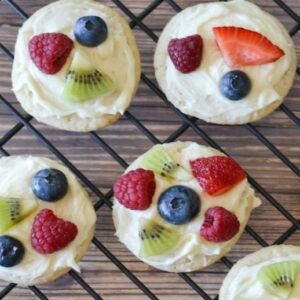 Mini Fruit Pizza cookies topped with an assortment of fruits placed on a cooling sheet