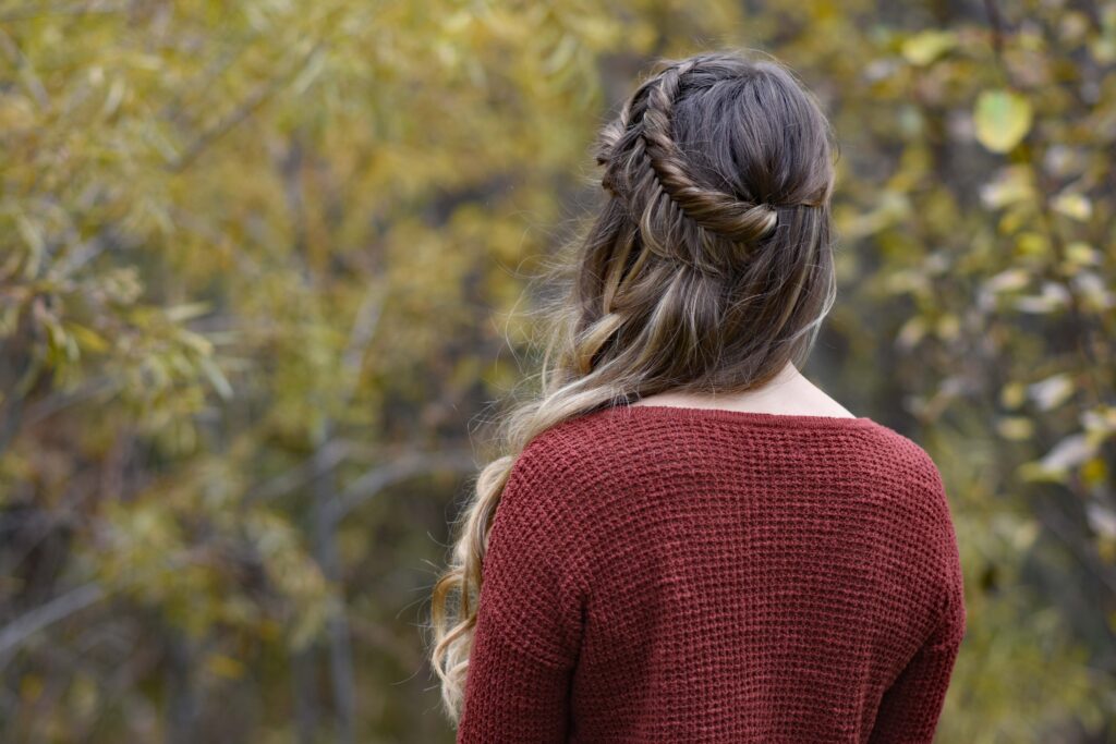 Back view of girl wearing red shirt outside modeling "Side Swept Fishtail" hairstyle