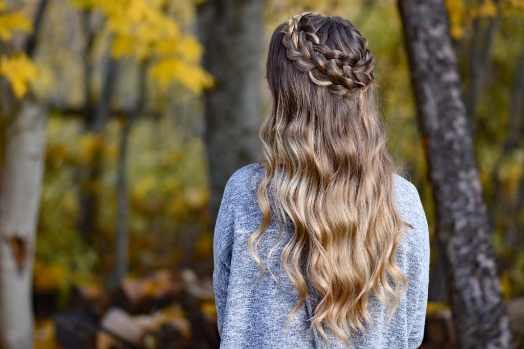 Back view of young woman outside wearing gray shirt, modeling "Dutch Halo Braid" hairstyle