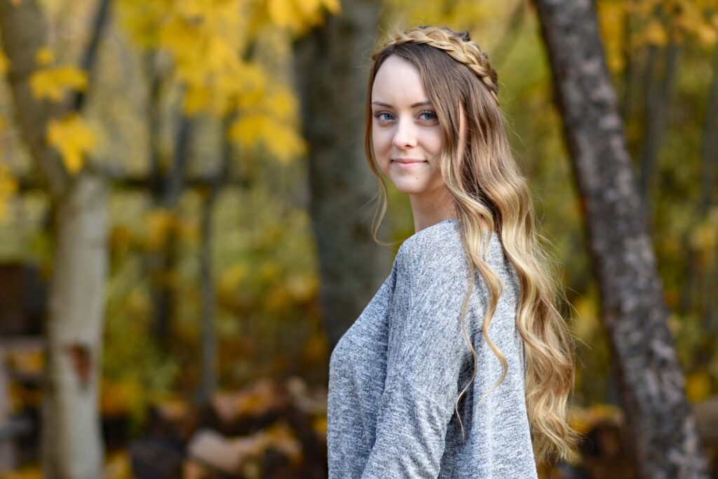 Side view of young woman outside wearing gray shirt, modeling "Dutch Halo Braid" hairstyle