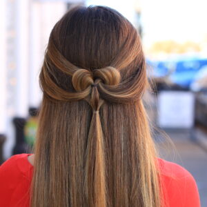 Back view of girl outside wearing a red shirt modeling "The Pancaked Heart" hairstyle