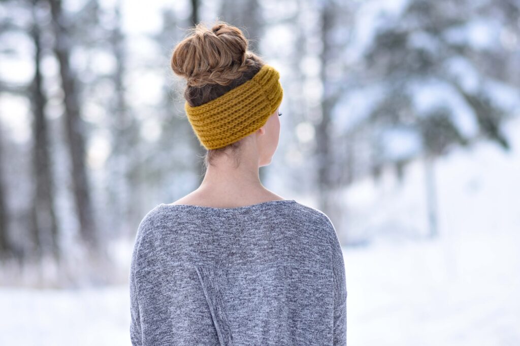 Back view of girl with a yellow headband modeling "Braided Bun" hairstyle