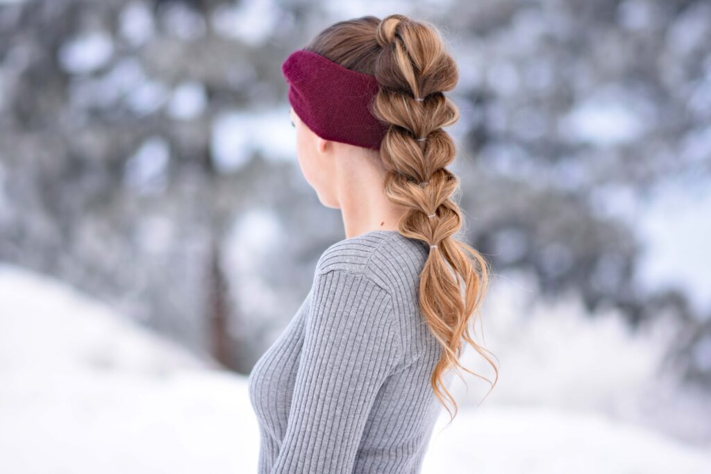 Side view of girl with long hair wearing a red headband modeling "Pull Thru Ponytail" hairstyle