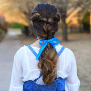 Back view of young girl with long in Halloween costume modeling "Belle Ponytail" hairstyle