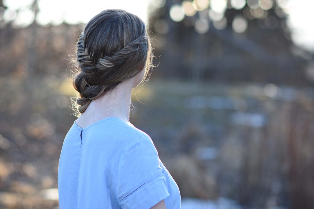 Side back view of young girl with long hair modeling "Side Pull Thru Combo" hairstyle