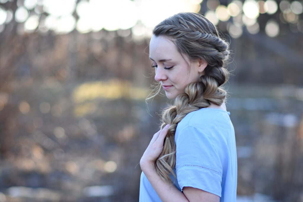 Profile view of young girl with long hair modeling "Side Pull Thru Combo" hairstyle