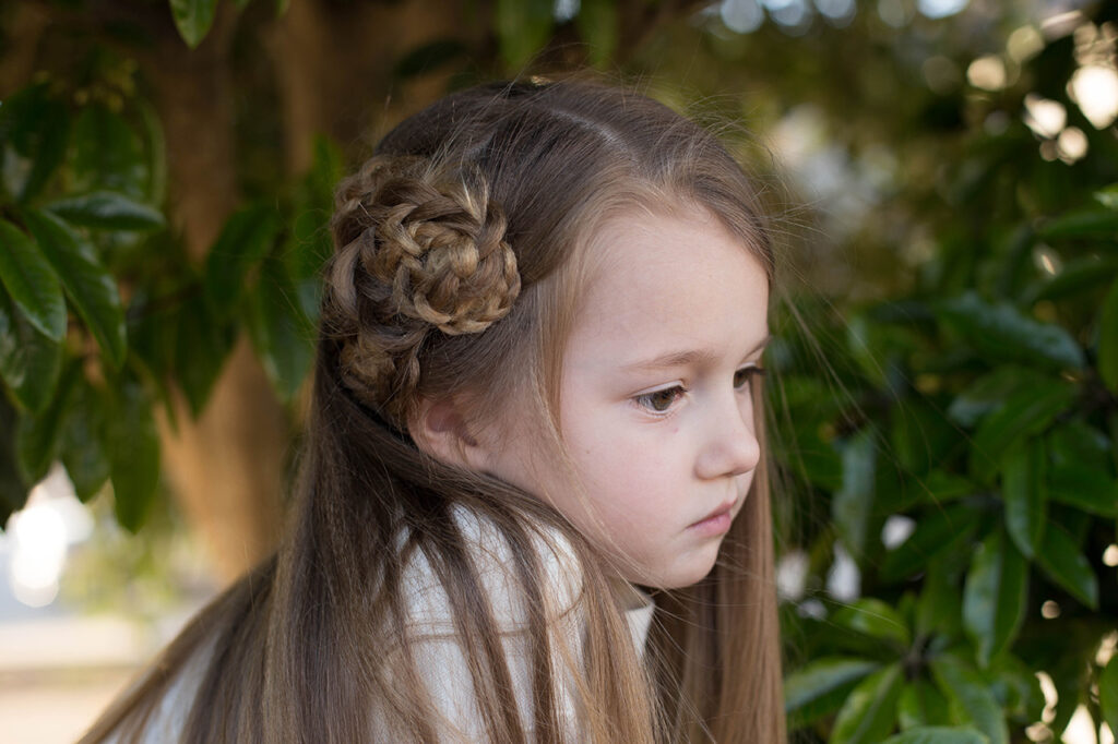 Profile of a young girl with long hair standing outside