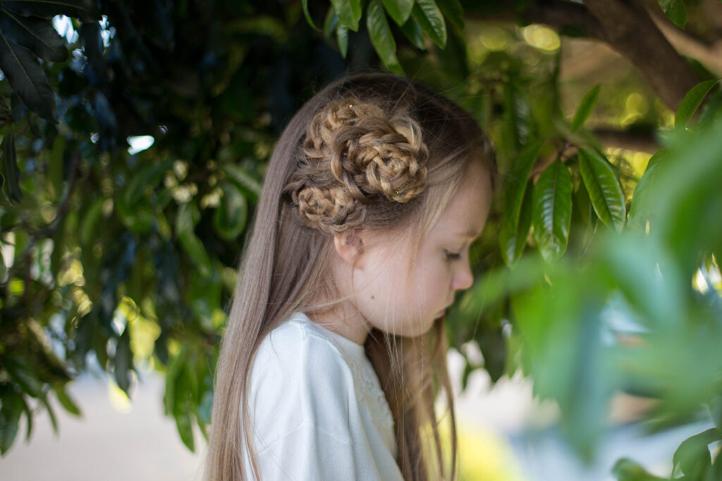 Side view of young girl outside modeling "Side Triple Flower" hairstyle