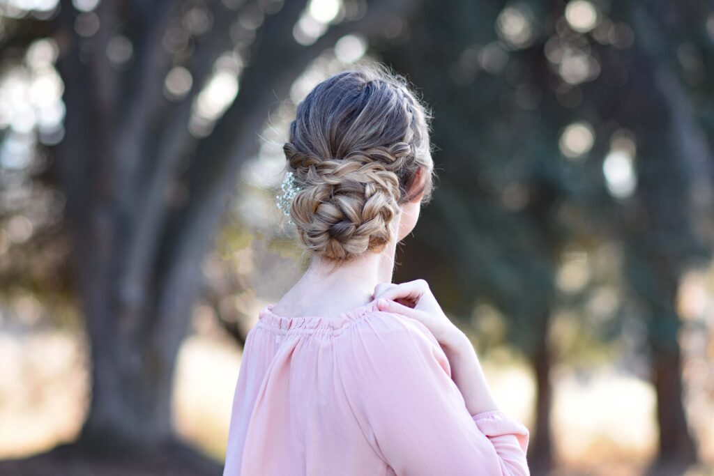 Back view of girl wearing a pink shirt standing outside modeling "Dutch Braided Updo" hairstyle