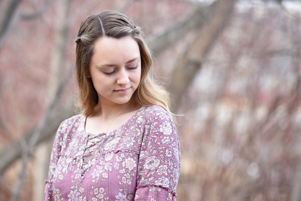 Portrait of young girl smiling standing outside in the forest