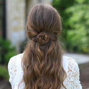 Back view of young girl with long hair standing outside modeling "Rosette Tieback" hairstyle