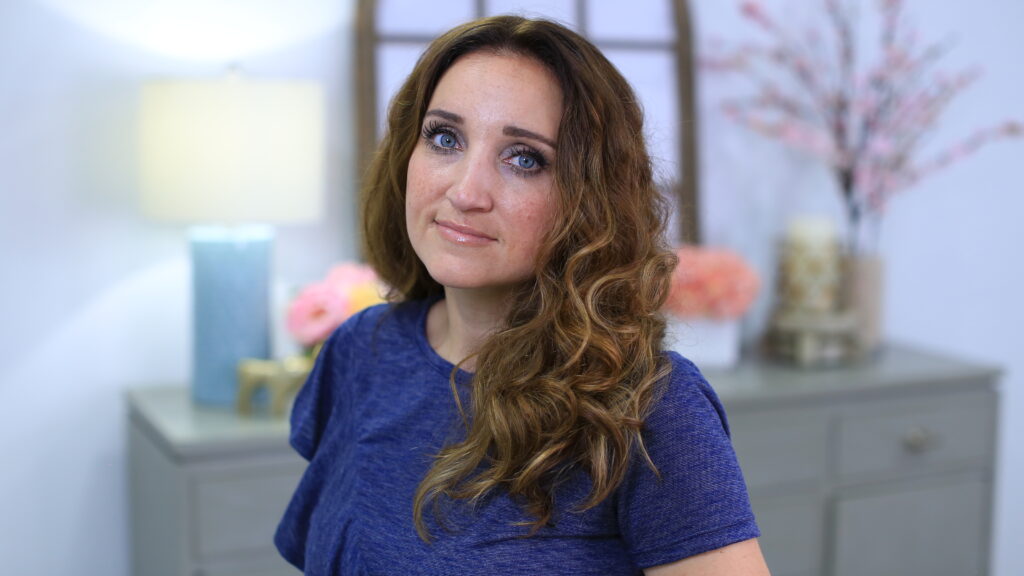 Portrait view of a woman with curly hair sitting in her room