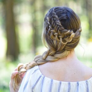 Back view of a young girl with long hair with a striped shirt standing outside modeling "Double Dutch Side Braid" hairstyle