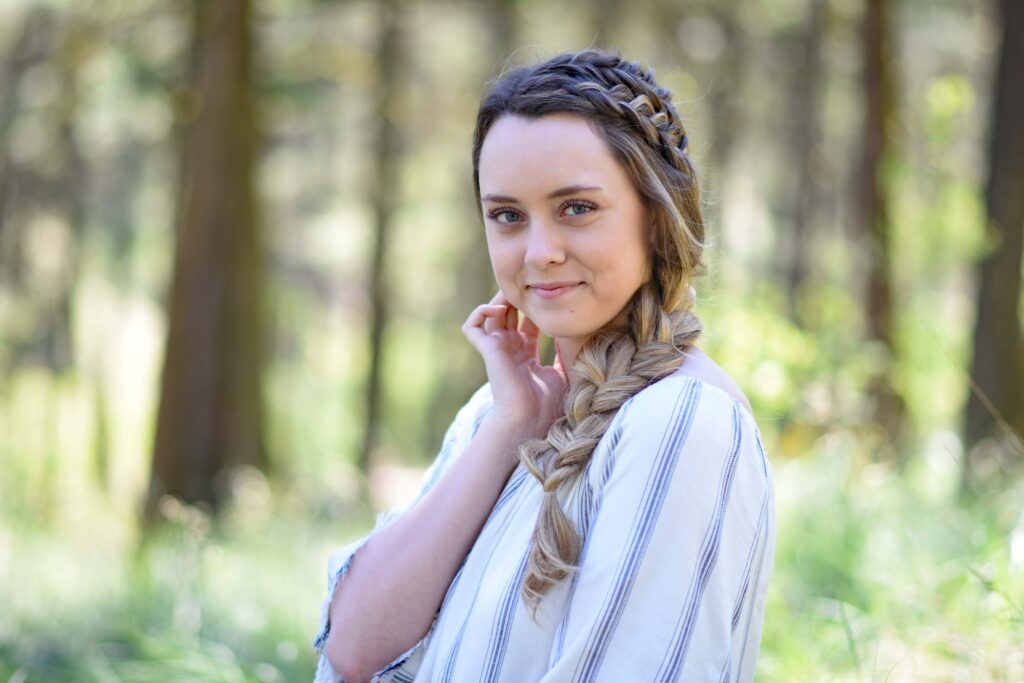 Portrait of young girl smiling while standing outside in the forest