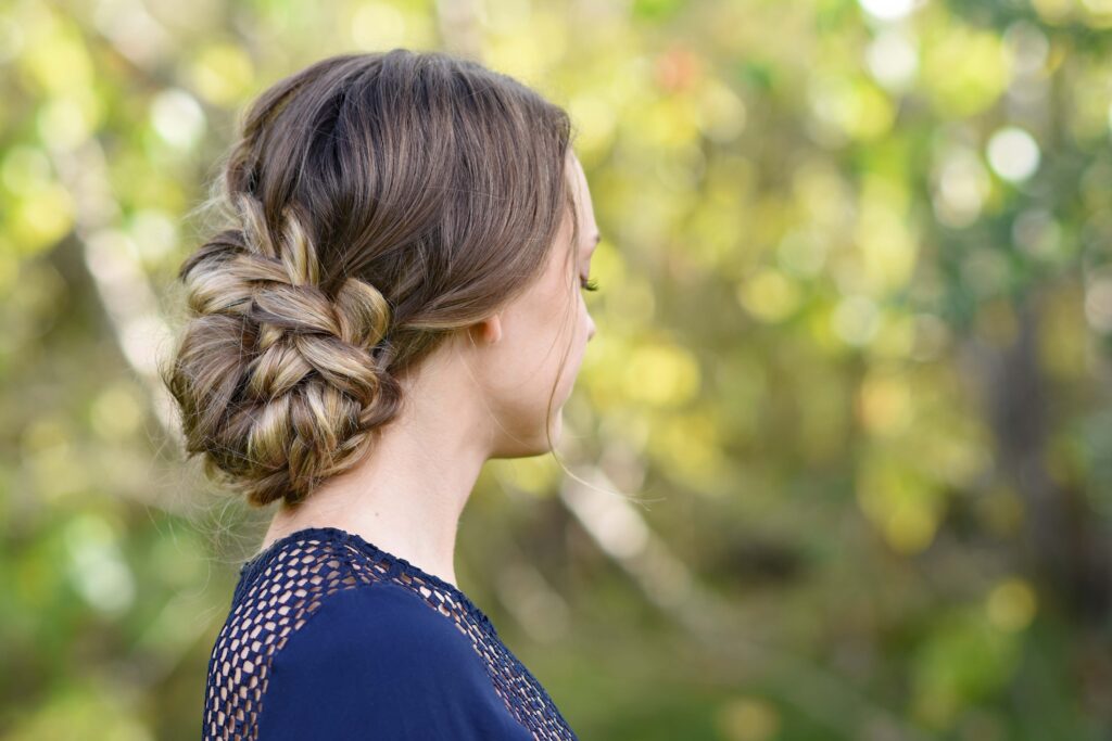 Side view of girl standing outside modeling the "French Braid Updo" hairstyle