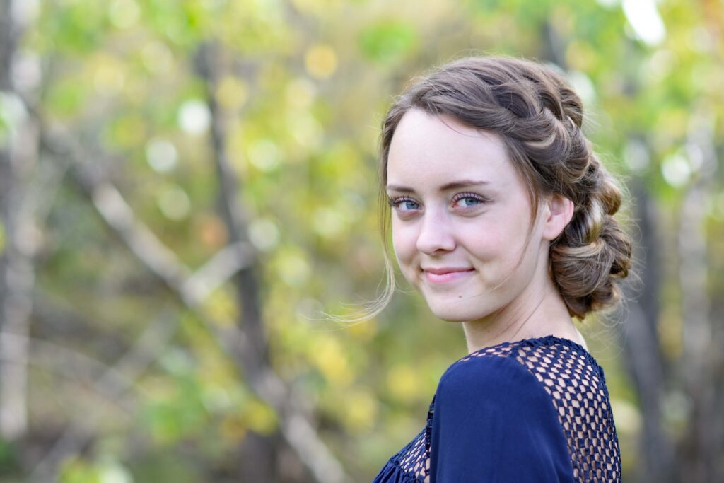 Portrait of young girl standing outside modeling the "French Braid Updo" hairstyle