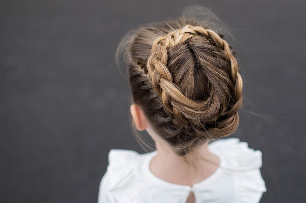 Top view of a little girl wearing a white shirt modeling "Halo Braid" hairstyle