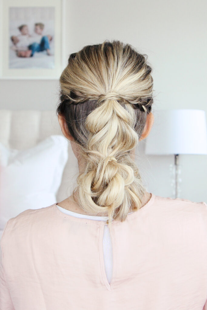 Close up back view of young woman standing in her room wearing pink shirt modeling "4-in-1 Pull Thru Braid" Hairstyle