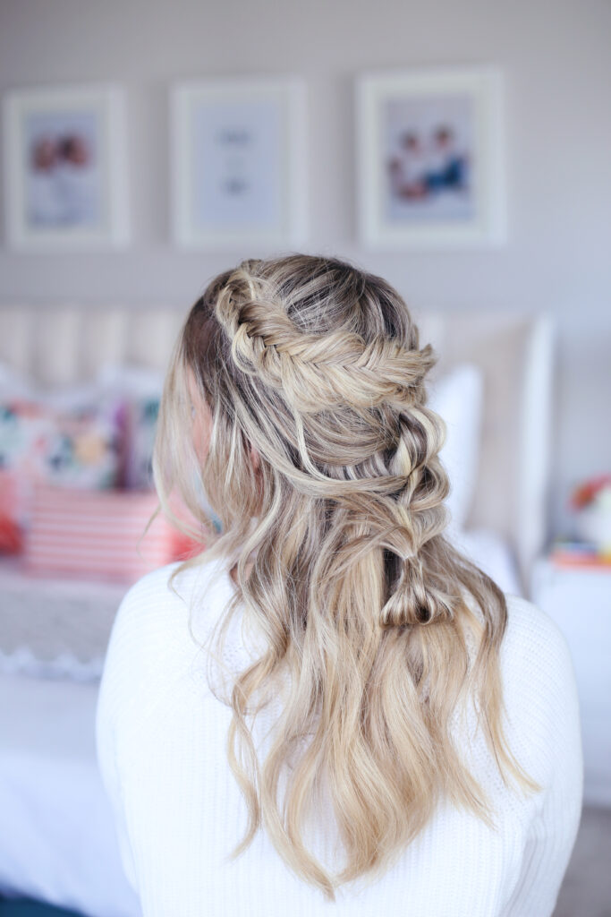 Close up back view of young woman standing in her room wearing a white shirt modeling "Mixed Braid Half Up" hairstyle