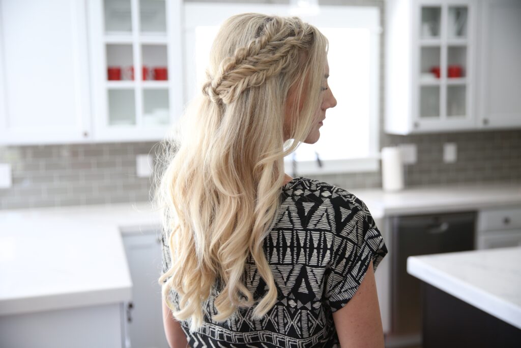 Side view of a blonde woman standing her kitchen modeling "Half Up Side Braid" hairstyle