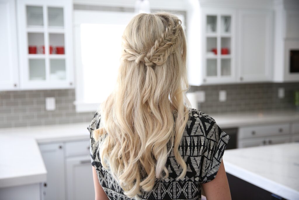 Back view of a blonde woman standing her kitchen modeling "Half Up Side Braid" hairstyle