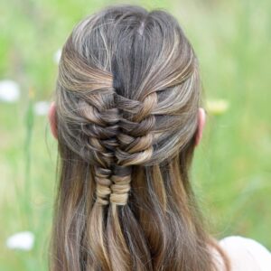 Close up back view of young girl standing in a meadow modeling "Floating Infinity Braid" hairstyle