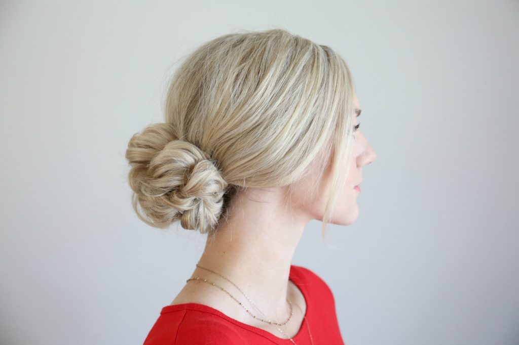 Profile of woman standing in front of a white background modeling the "Pull Thru updo" hairstyle