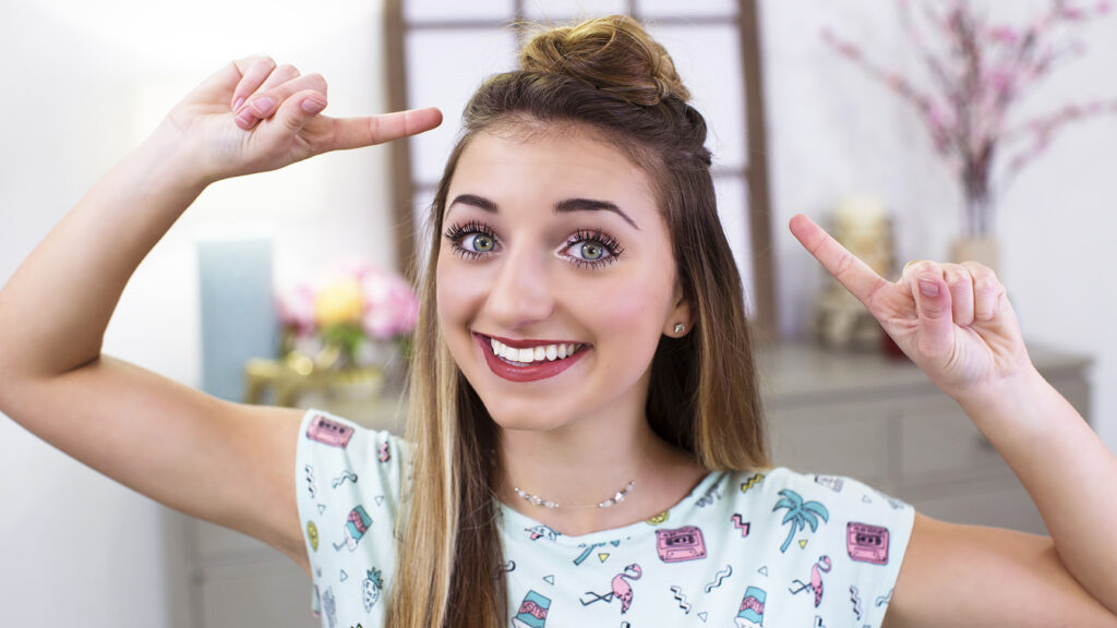 Portrait of young girl smiling and pointing at her head modeling "Triple Top Knot" hairstyle