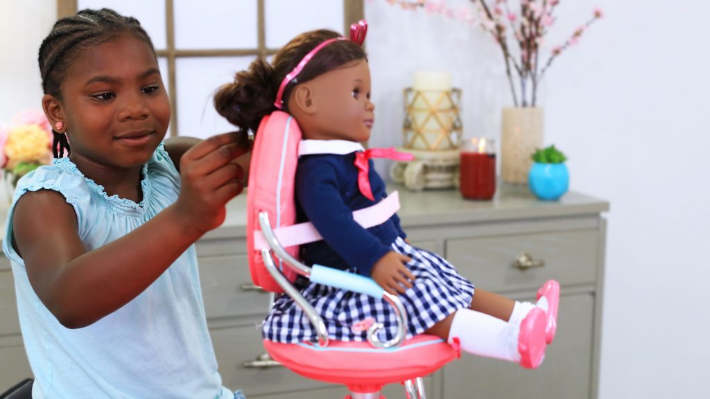 Young African American girl playing indoors with her doll