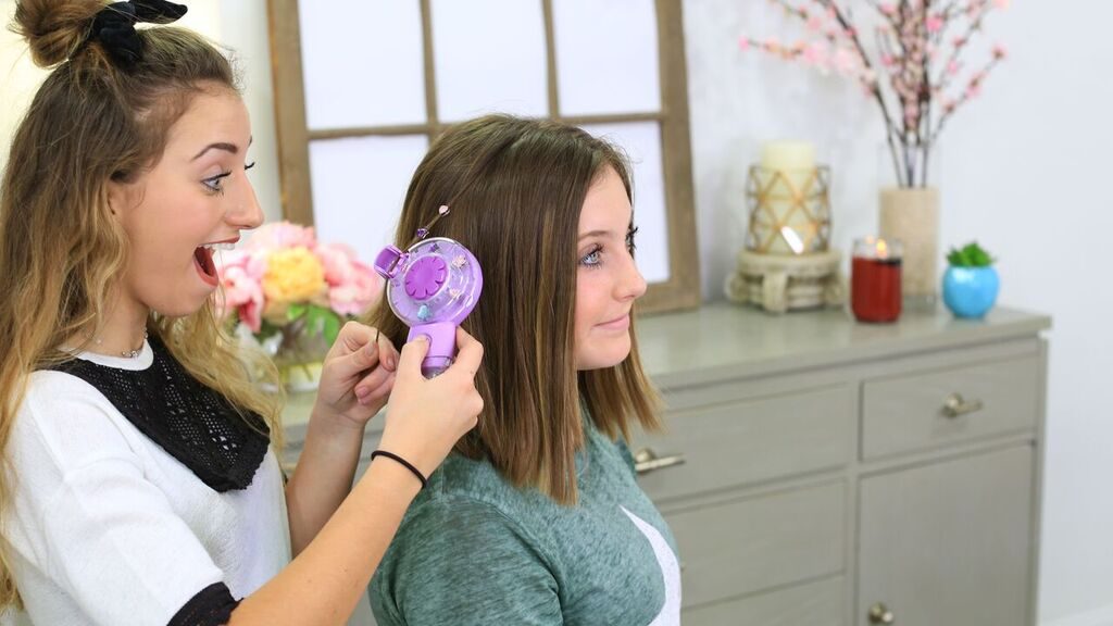 Two sisters using products to style each other's hair. 