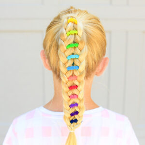 Back view of young girl standing outside with a pink shirt modeling multicolor "Banded Ponytail" hairstyle