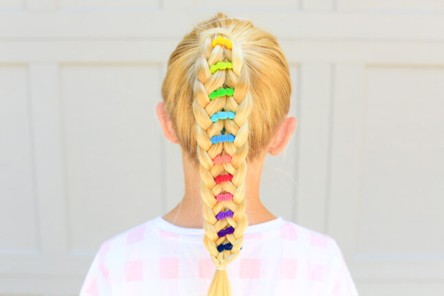 Back view of young girl standing outside with a pink shirt modeling multicolor "Banded Ponytail" hairstyle