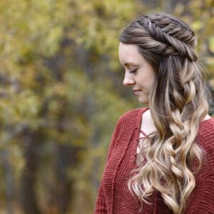 Back view of girl with red shirt standing outside modeling "Side Swept Fishtail" hairstyle