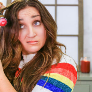 A woman using a curling iron to style her hair.