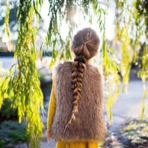 Back view of girl standing outside in forest modeling the "Dutch Pull-Thru Combo Braid" hairstyle