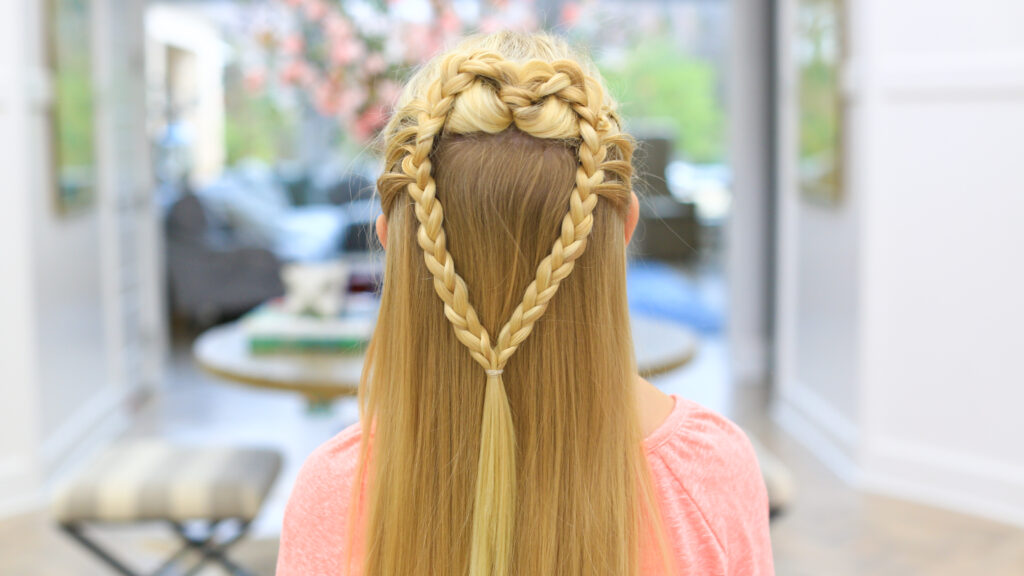 back view of a girl with long blonde hair standing indoors modeling the "Mermaid Hair Braid" hairstyle