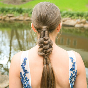 back view of burnette girl with standing by pond with low infinity braid combo hairstyle.