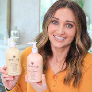 Women sitting in the bathroom holding a shampoo bottle and a conditioner