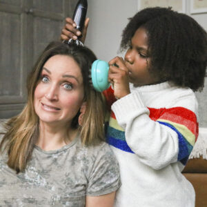 Mother and daughter are testing multiple head massagers on the mother's head.