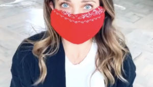 Portait of woman sitting on the floor wearing a red homemade bandana mask