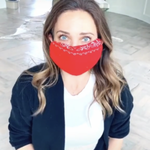 Portait of woman sitting on the floor wearing a red homemade bandana mask